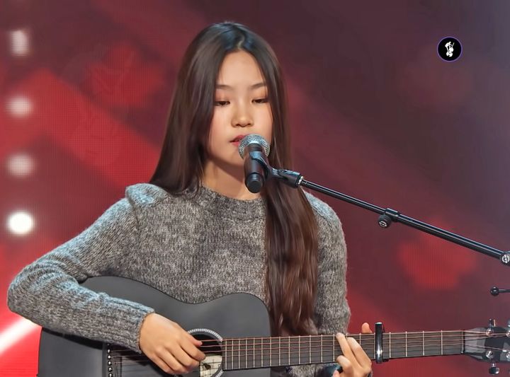 A 14-years-old takes the stage for a life-changing audition. Singing an acoustic cover of Like My Father, inspired by her parents, her impressive voice wows everyone. She earns a golden buzzer and